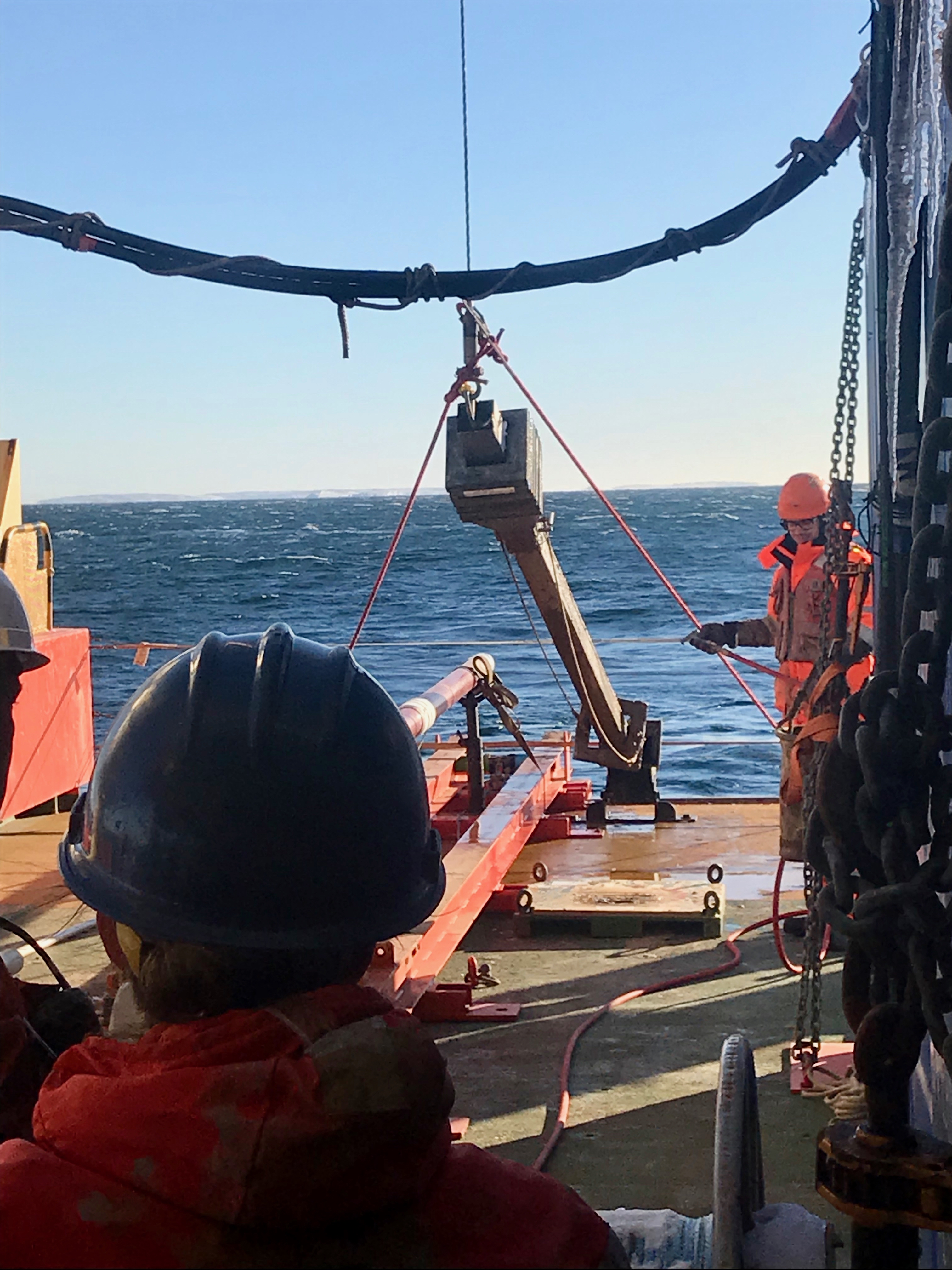 Peter Sheehan helps to secure and hose off the Kasten core just brought back up from the seafloor. Becky Minzoni waits excitedly for the core to be secured on the ship so that her team can open up the core to see if they successfully captured a sediment core.