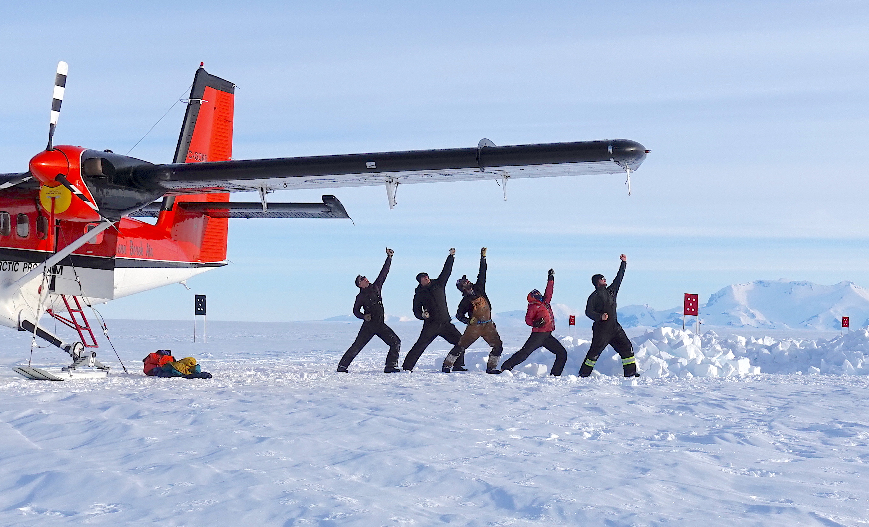 Figure 11. The TARSAN Team strikes a victory pose on Dotson Ice Shelf -- Ken Borek Air pilots Rodney Fishbrook, Jenia Rubel, Christian Wild, Keira Solomon, and Jesse (C. Wild)