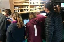Scientists gather around computers to learn the latest discoveries about the Thwaites Glacier ice shelf.