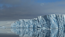 A glacier reflected in flat ocean water