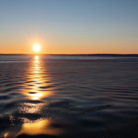 Grease ice dampens ripples in the water near sunset over the Amundsen Sea. Photo credit: Carolyn Beeler/The World