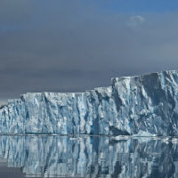 A glacier reflected in flat ocean water