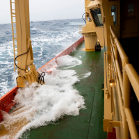 Huge waves crash up onto the deck of the Nathaniel B. Palmer as it crosses the Drake Passage. Credit: Carolyn Beeler/The World