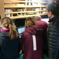 Scientists gather around computers to learn the latest discoveries about the Thwaites Glacier ice shelf.